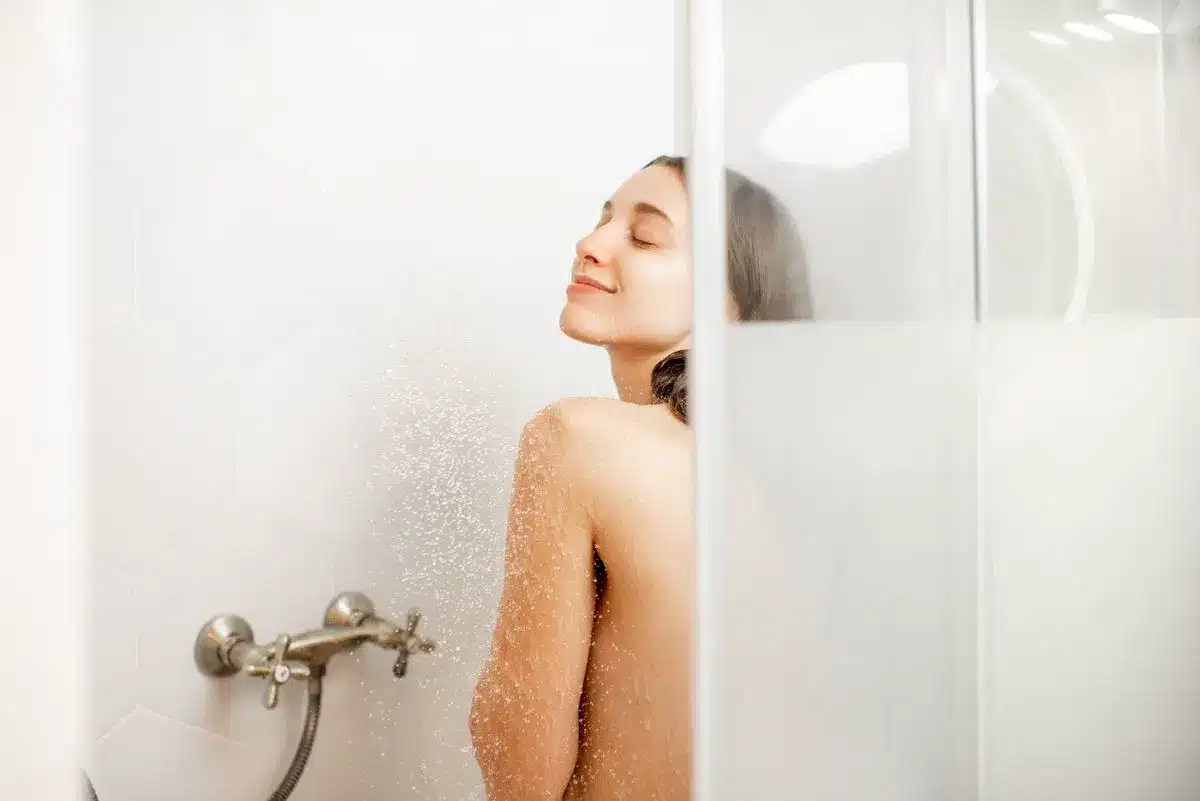 Femme prenant une douche grace a l'eau chaude de sa pompe à chaleur